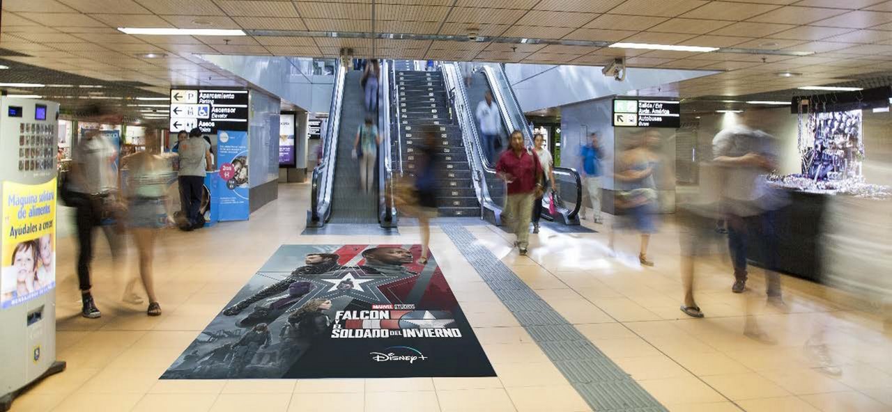 Vinilo publicitario de gran formato espectacular en suelo de acceso a intercambiador de Madrid